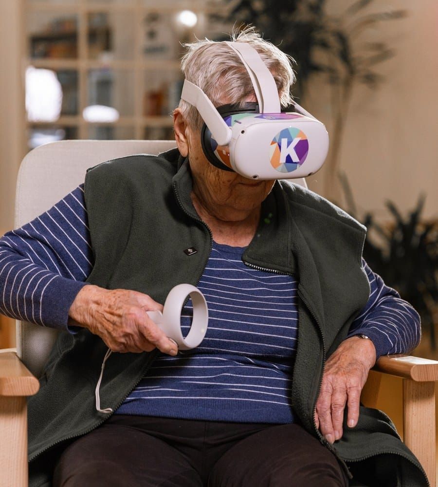 Klientka s VR brýlemi drží v ruce ovladač Kaleido Kognice