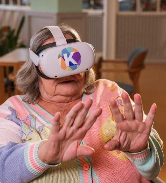 Klientka s VR brýlemi reaguje pohybem rukou v Kaleido Motorice